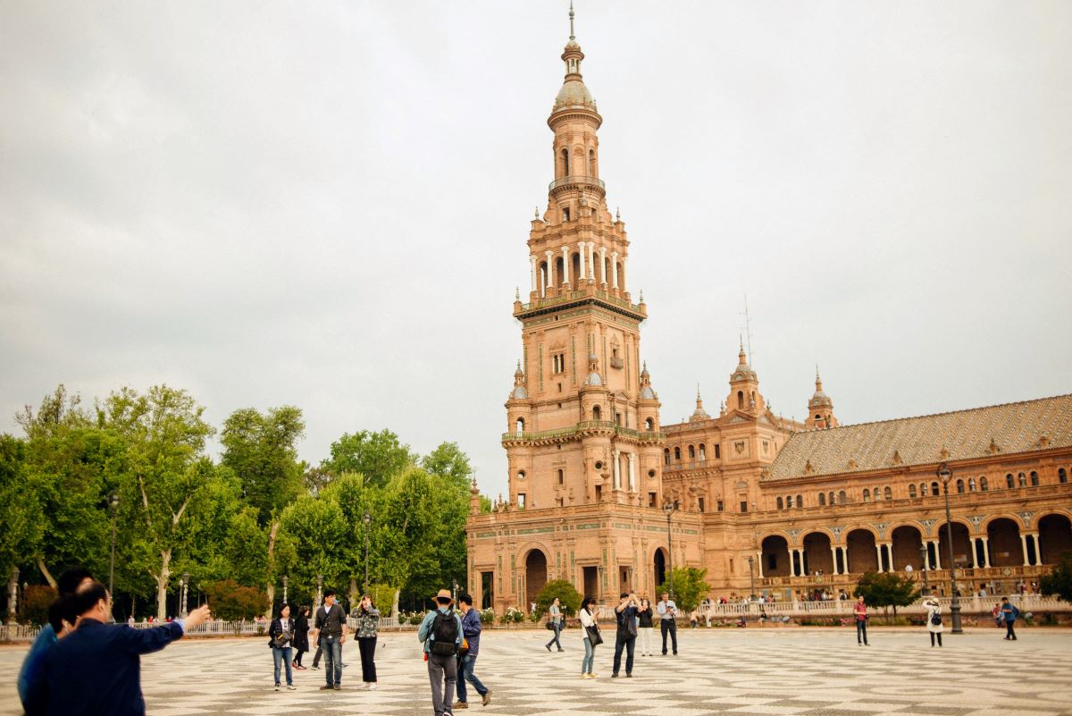 People walking through Plaza de España in October in Seville.
