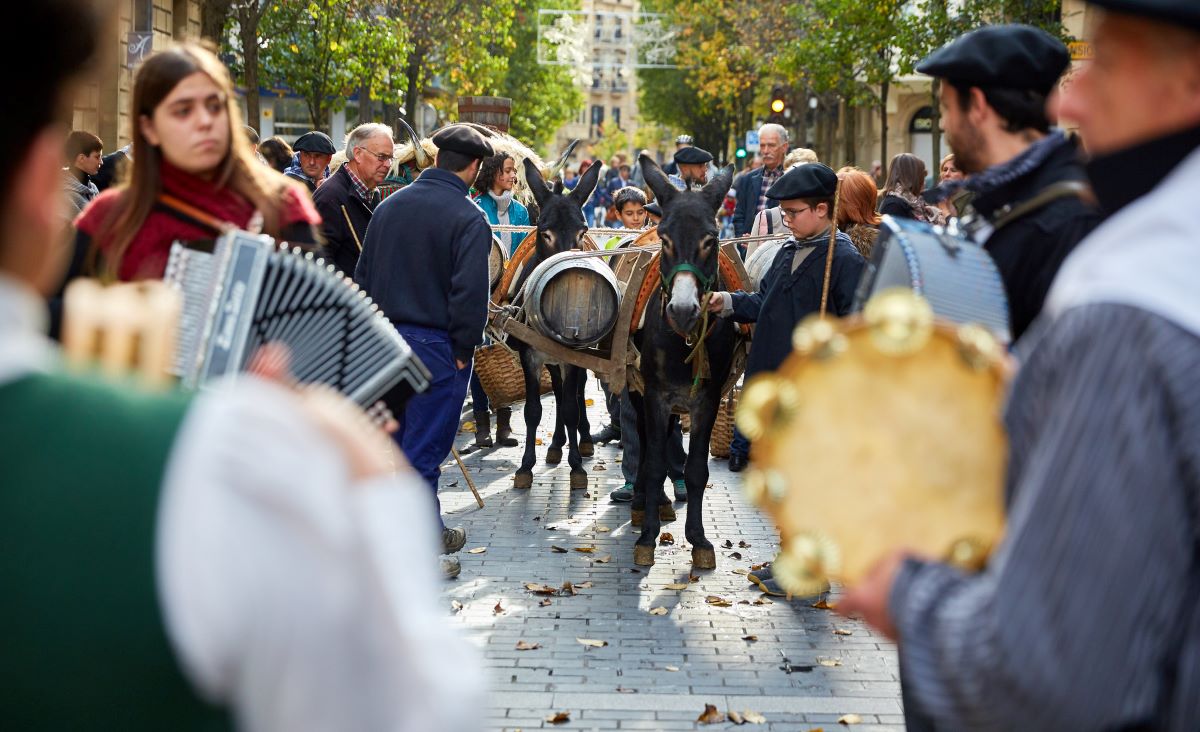 People at Euskal Jaiak playing music as donkeys walk in the background. 