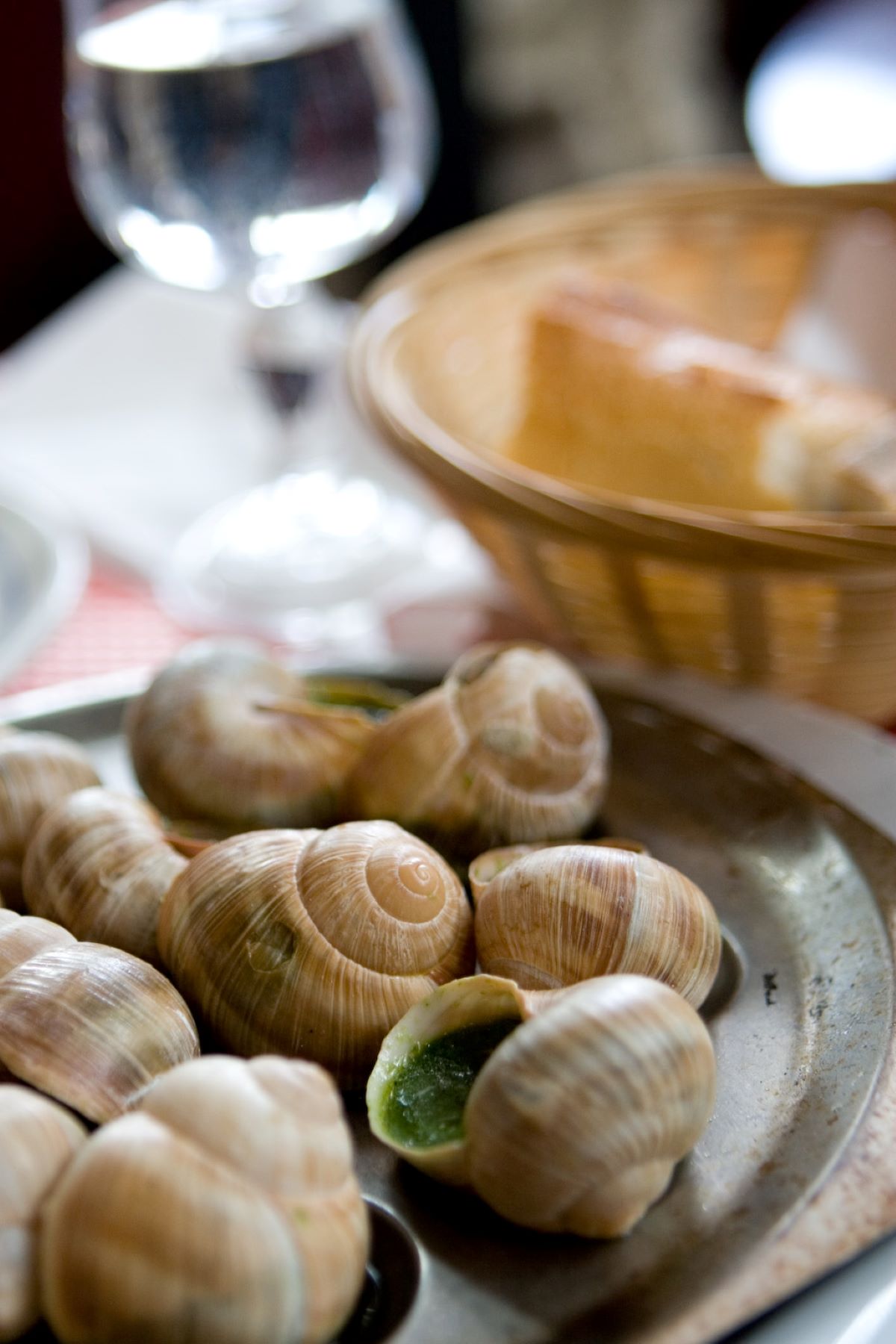 plate of famous paris food with bread and wine in the background