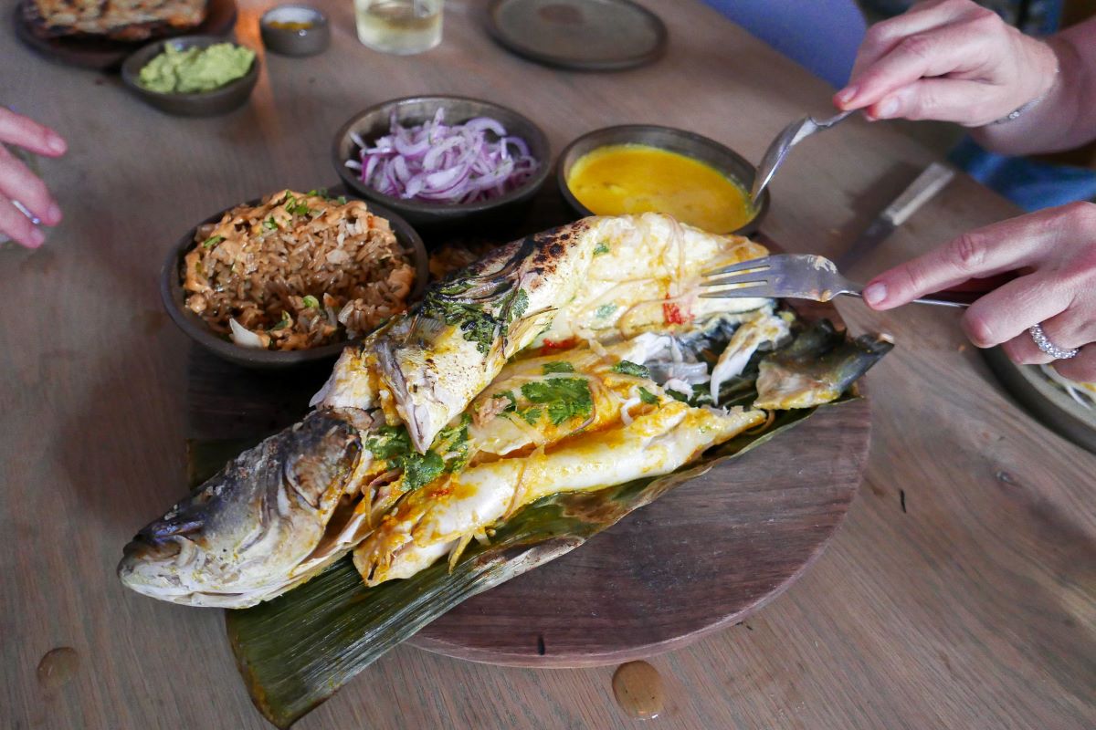 A whole Branzino Patarashca on a banana leaf made at one of the top NYC Peruvian restaurants, Llama Inn.