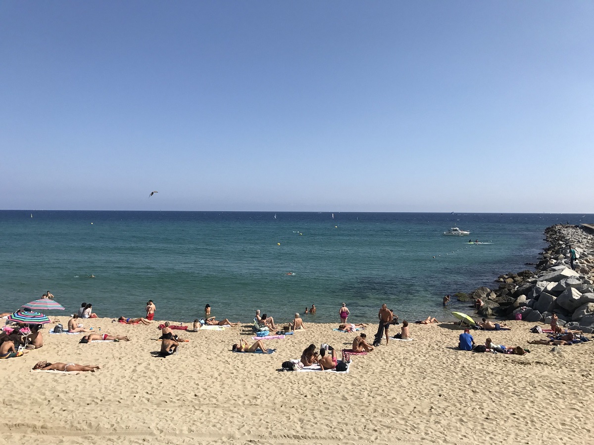 Beach goers laying out on the sand at one of Barcelona's many sandy beaches