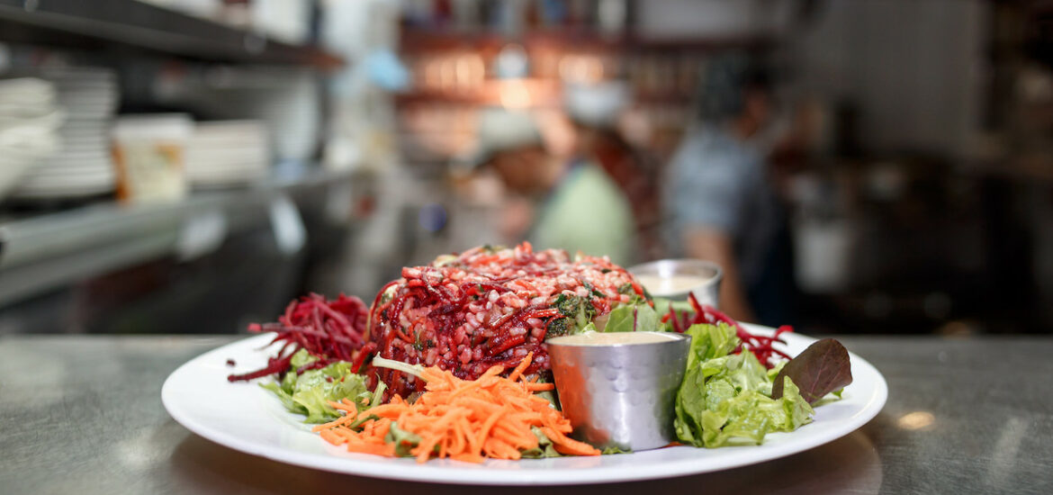 A white plate ready for service piled high with vegetables