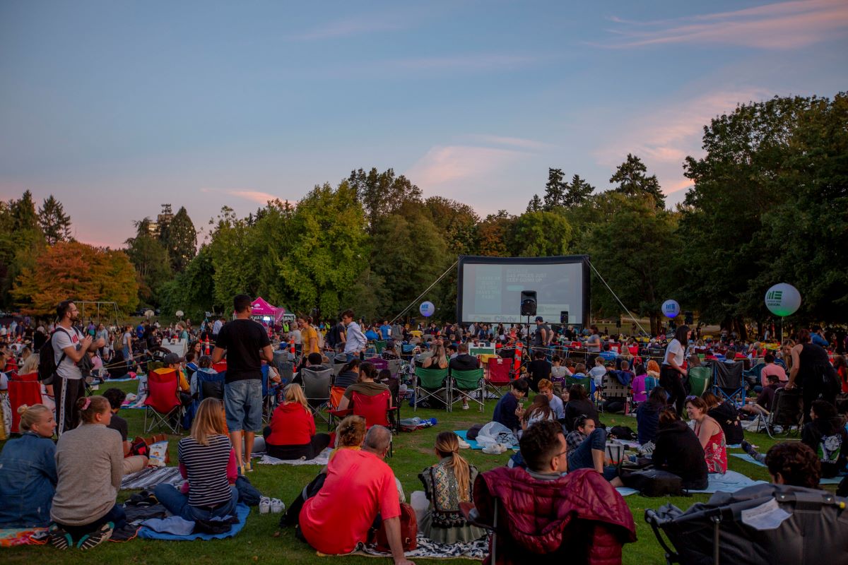 people watching a movie outside in an outdoor cinema