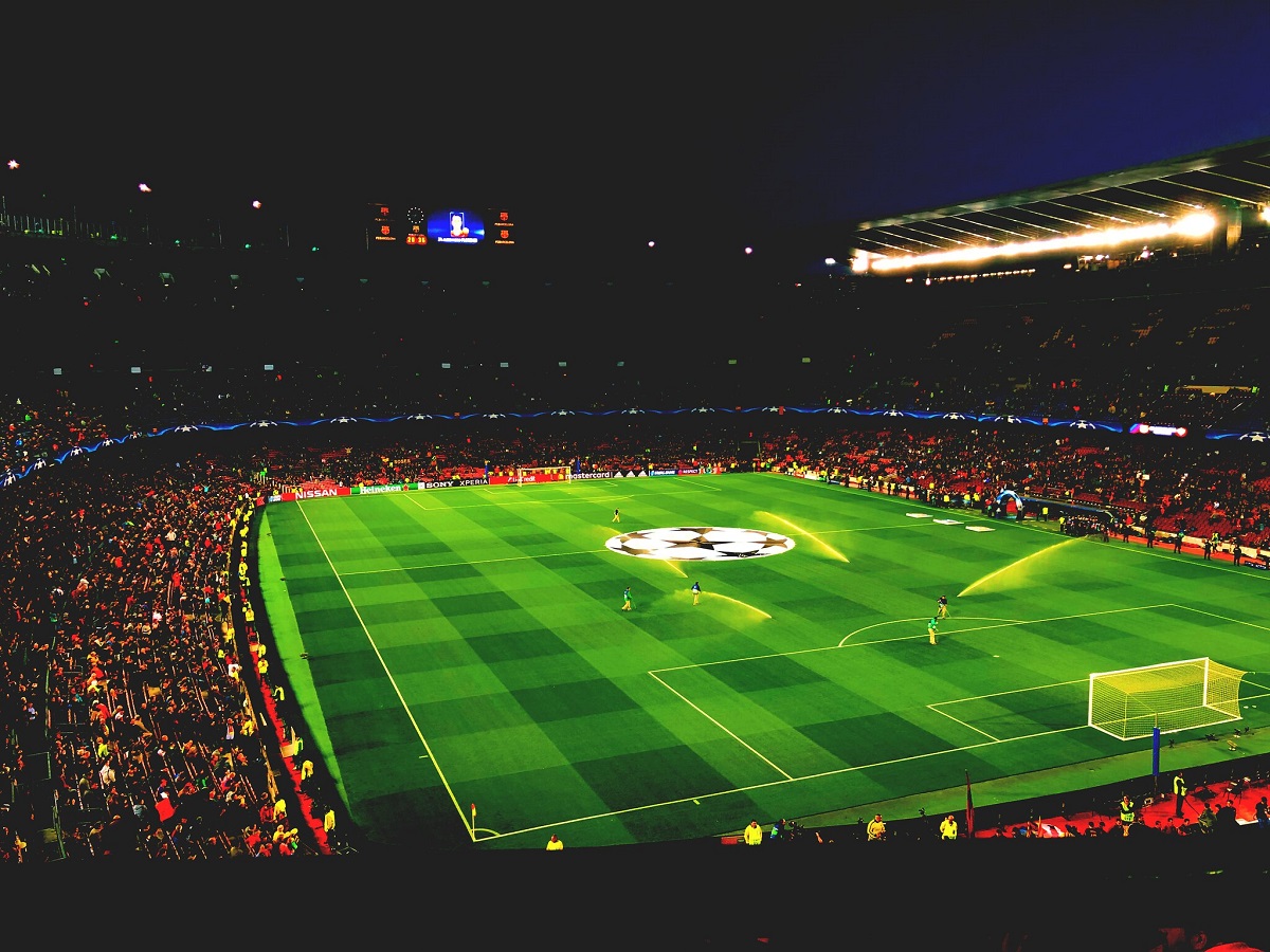 Barcelona football stadium Camp Nou at night with bright lights and tons of fans filling the seats