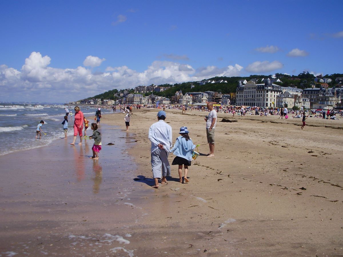 people walking on the beach during a day trip from paris