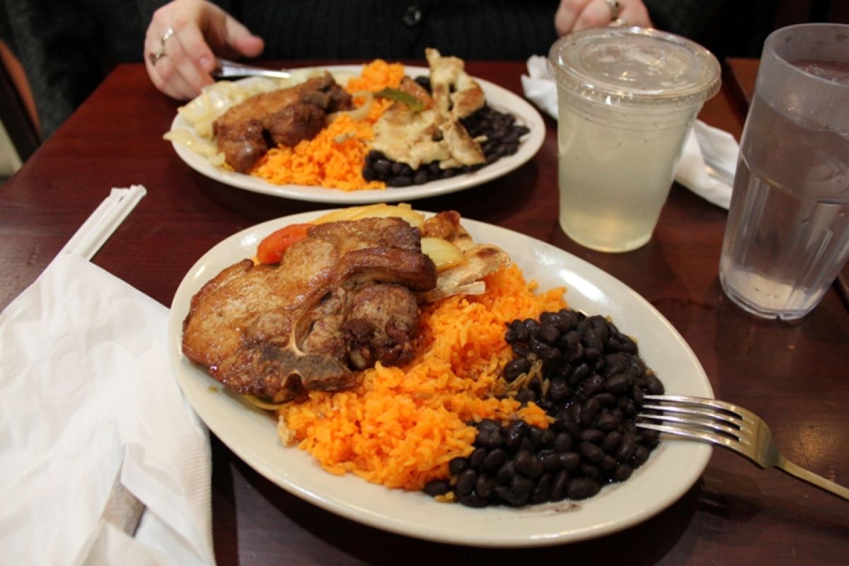 People eating plates of chicken, rice, and beans from Sophie’s Cuban.