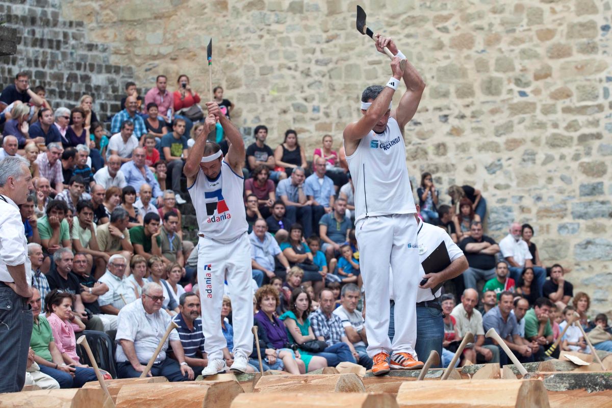 Two competitors competing in a wood chopping event. 