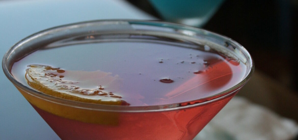 Colorful cocktails with orange garnishes on a black table