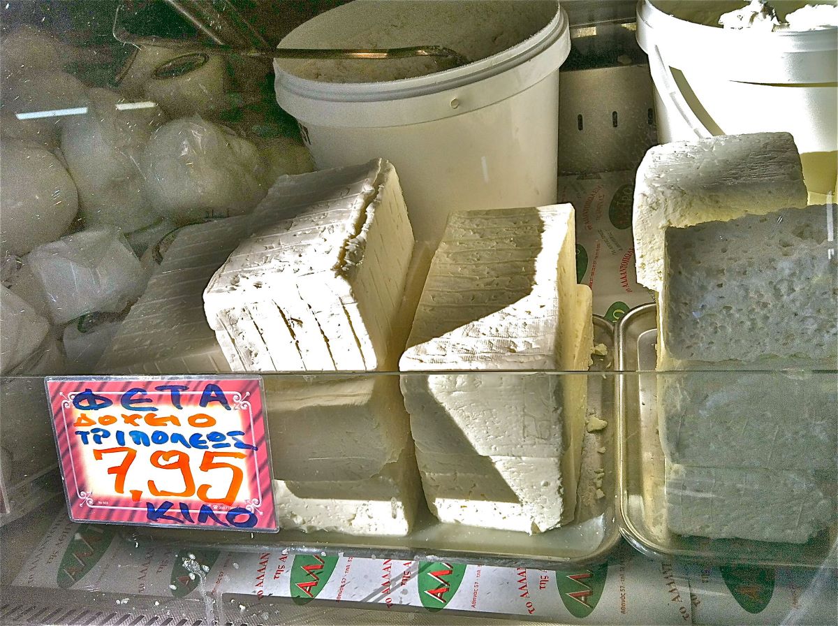 display of large chucks of white cheese in market stall