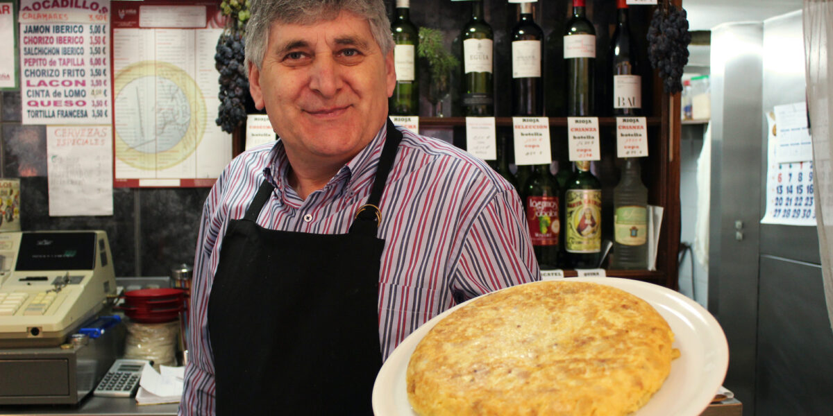 man holding a plate of eggs and potatoes