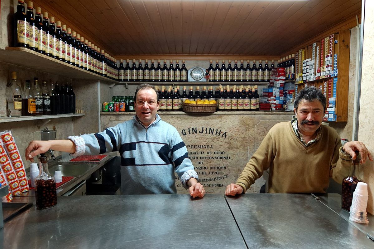 The owners of A Ginjinha standing in the bar. 