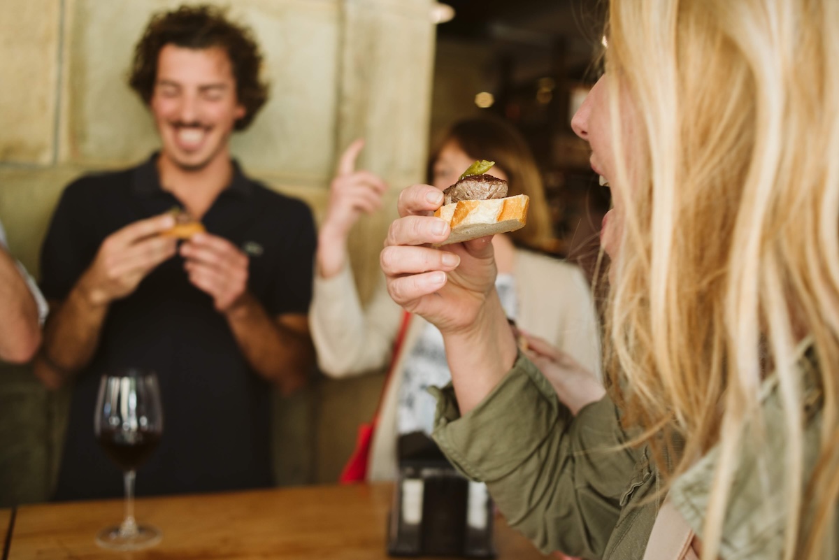 people eating and drinking together around a table