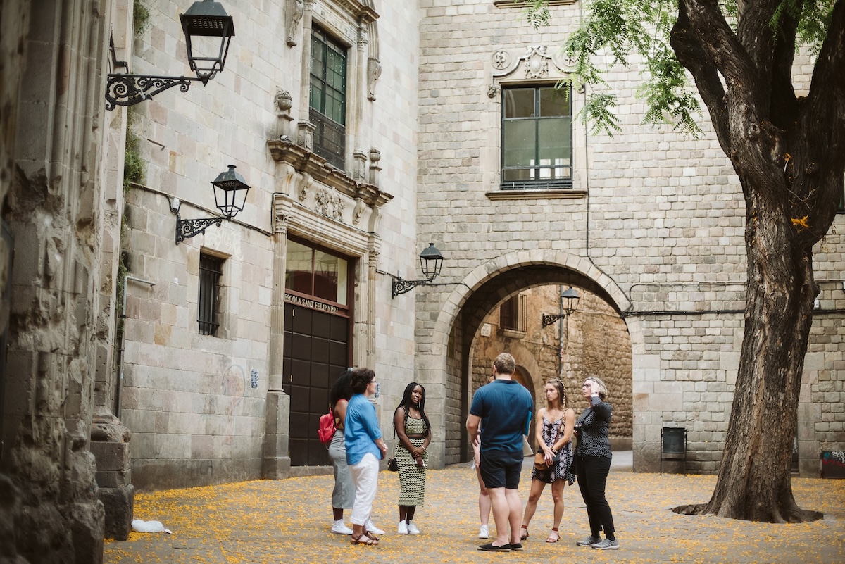 People on a walking tour learning about Barcelona's Gothic Quarter. 