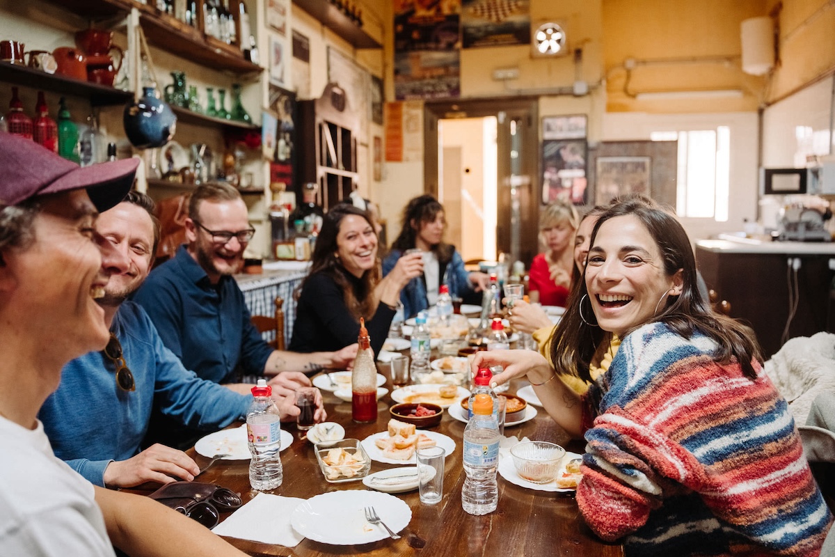 Group of people at a table enjoying food and drinks