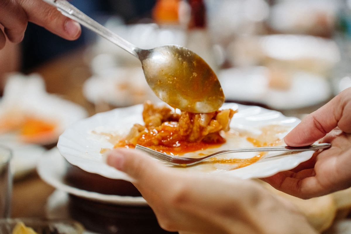 white plate of pasta with orange sauce