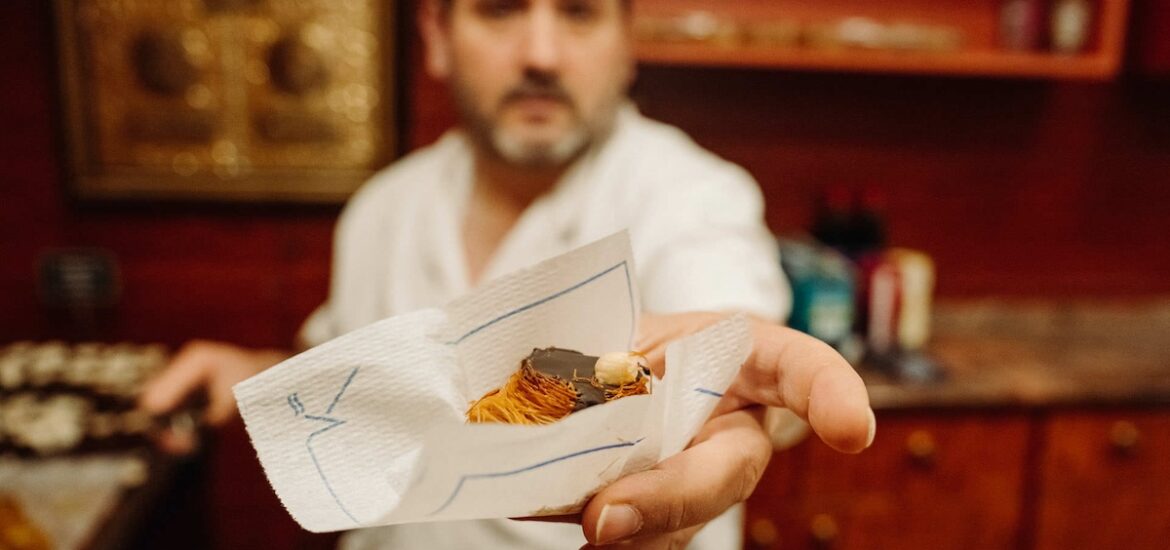 man offering chocolate treat in paper napkin