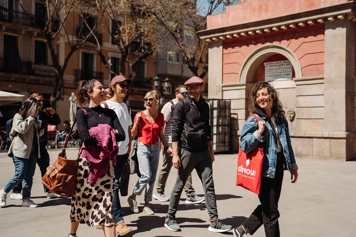 a group of people following a tour guide with red bag
