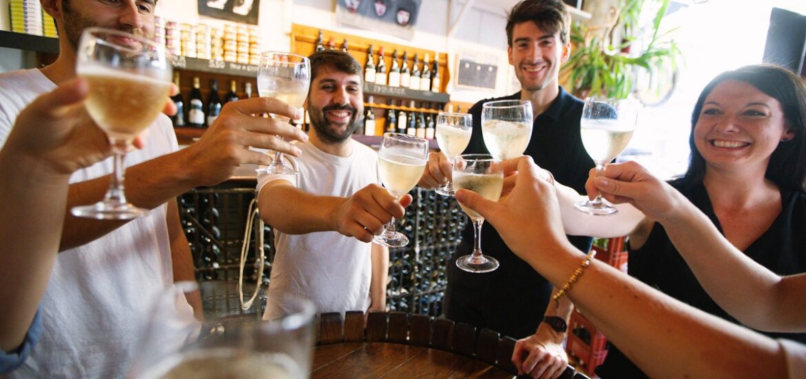 Group of friends toasting with white wine at a wine bar in Bordeaux