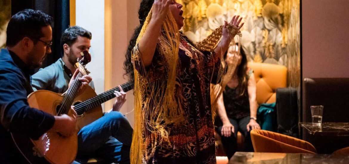 Fado show with singer, guitarists, and viewers at a restaurant in Lisbon, Portugal