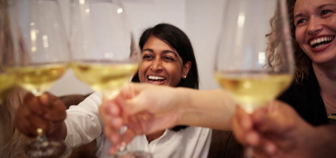 two women toasting with wine glasses