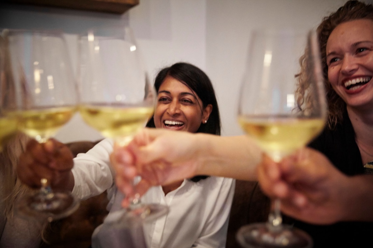 two women toasting with wine glasses