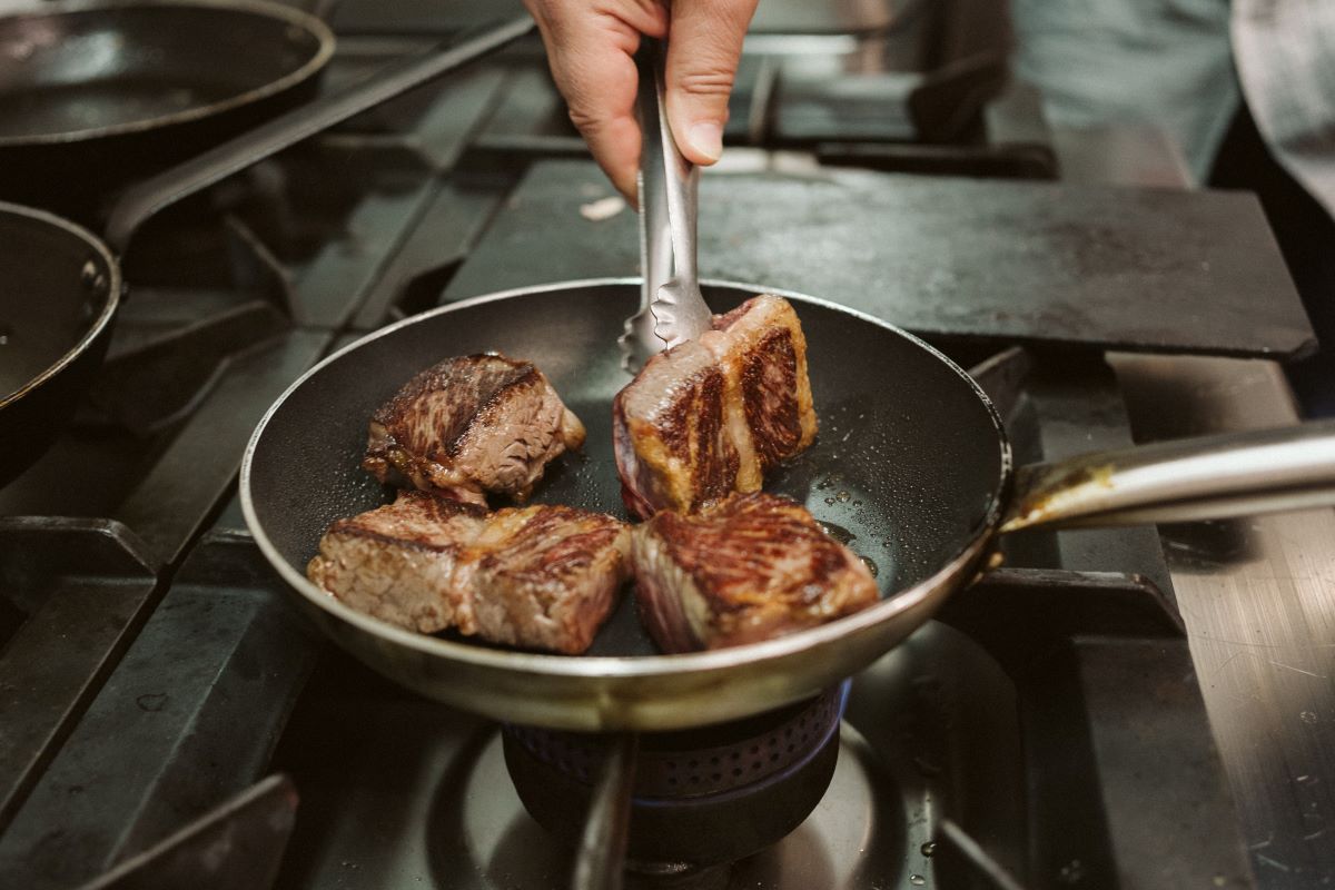 A chef preparing four pieces of txuleta in San Sebastian, Spain. 