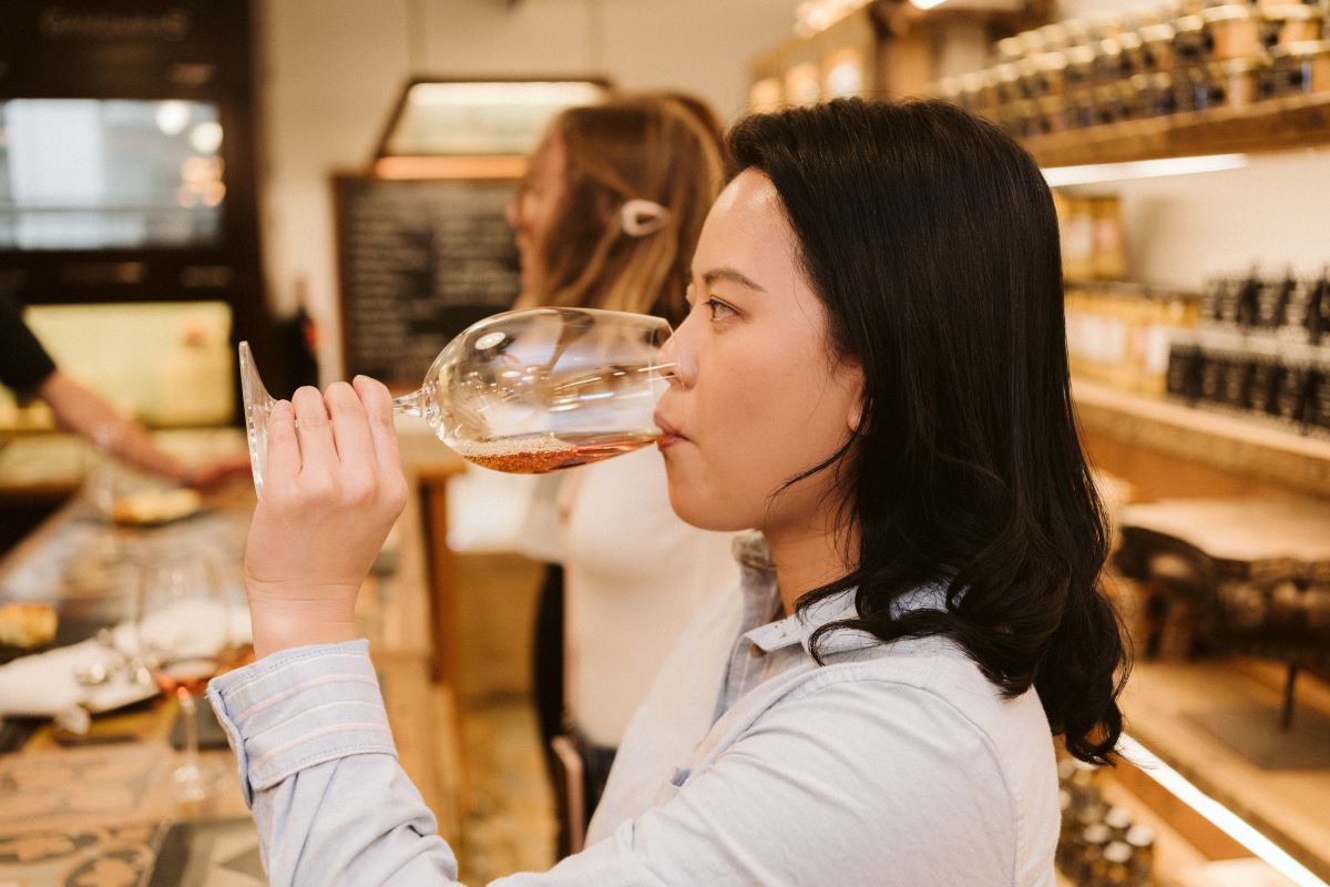 A woman takes a sip of wine