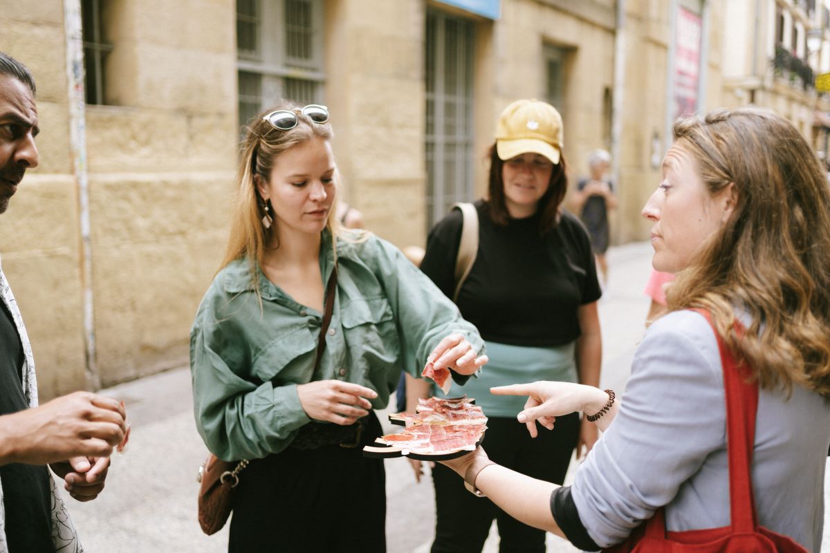 A guest samples a bite of jamon while on a food tour in San Sebastian