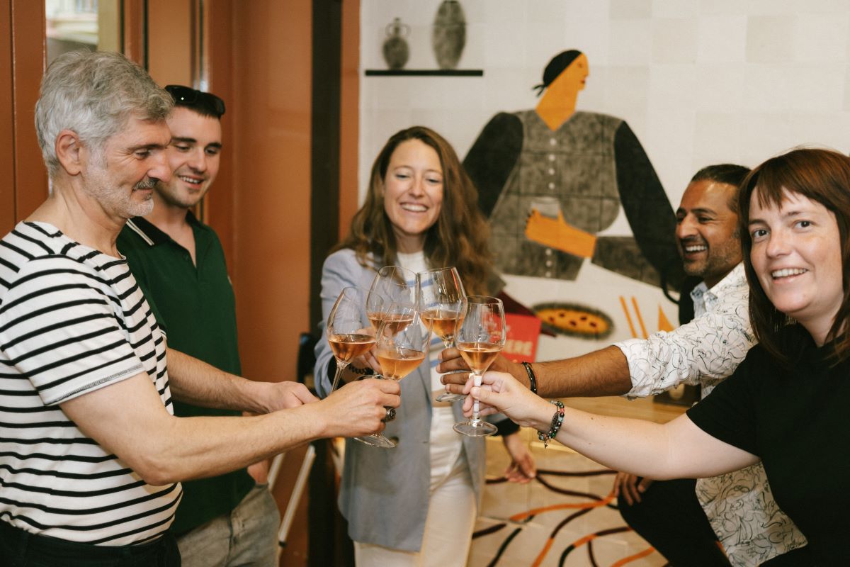 A group does a cheers with wine