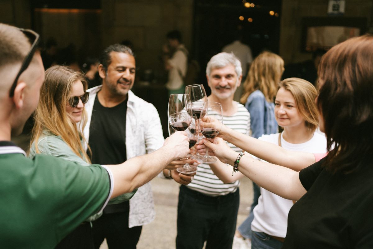A group does a cheers with wine