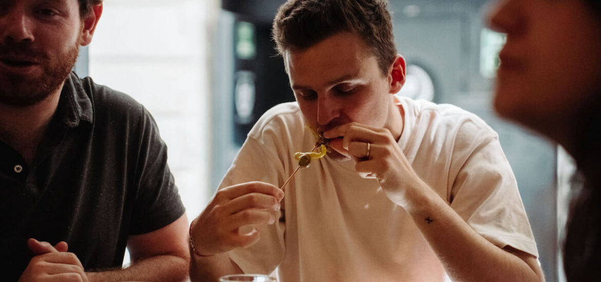 Person eating a tapa with drinks, gilda.