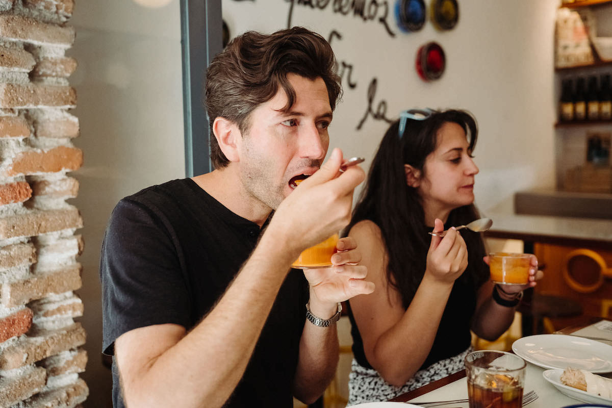 Person eating salmorejo, Spanish tapa, with drinks