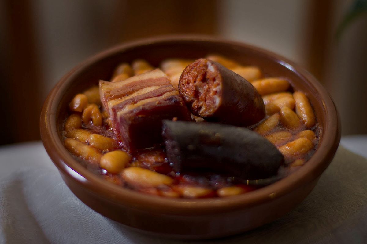 A bowl of certified Faba Beans with a Denomination of Origin Spain seal, cooked into a fabada. 