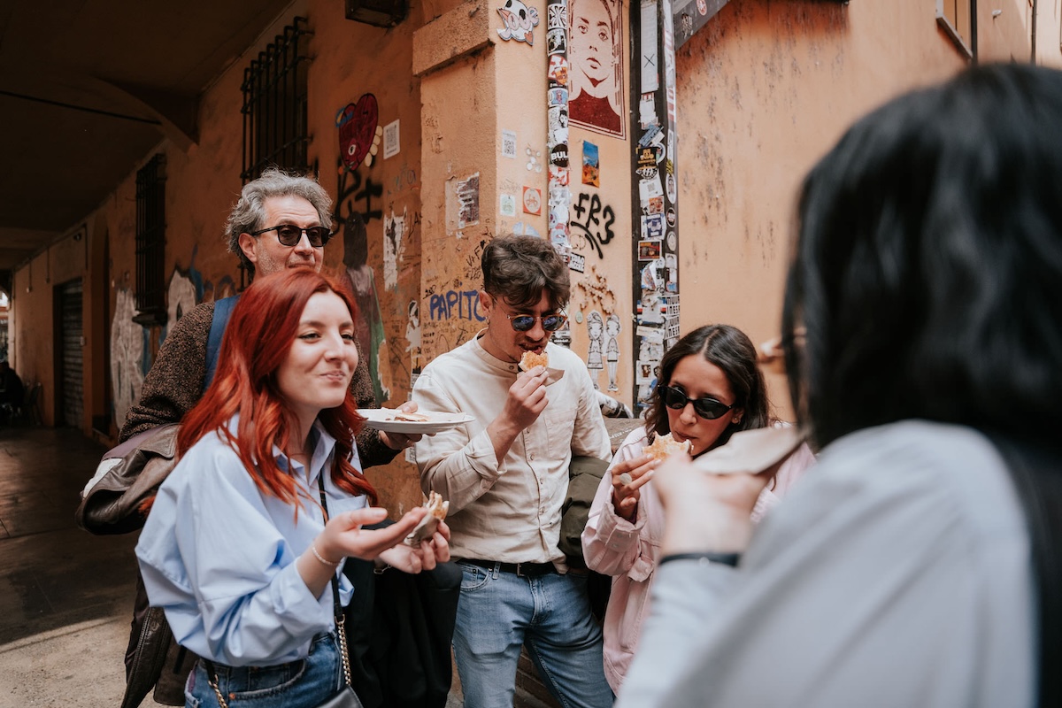 group of people on the street enjoying a bite of something