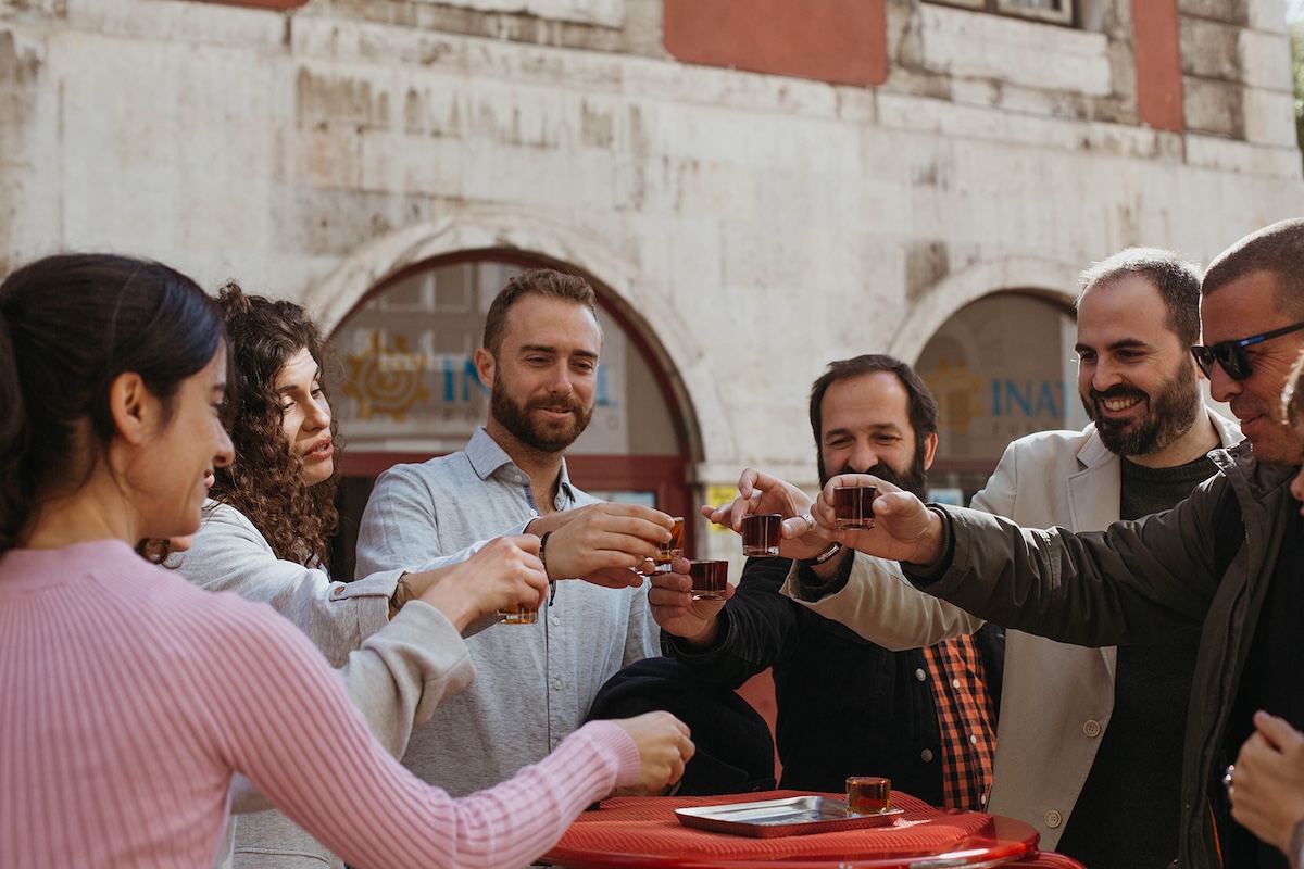 group of people toasting with small glasses