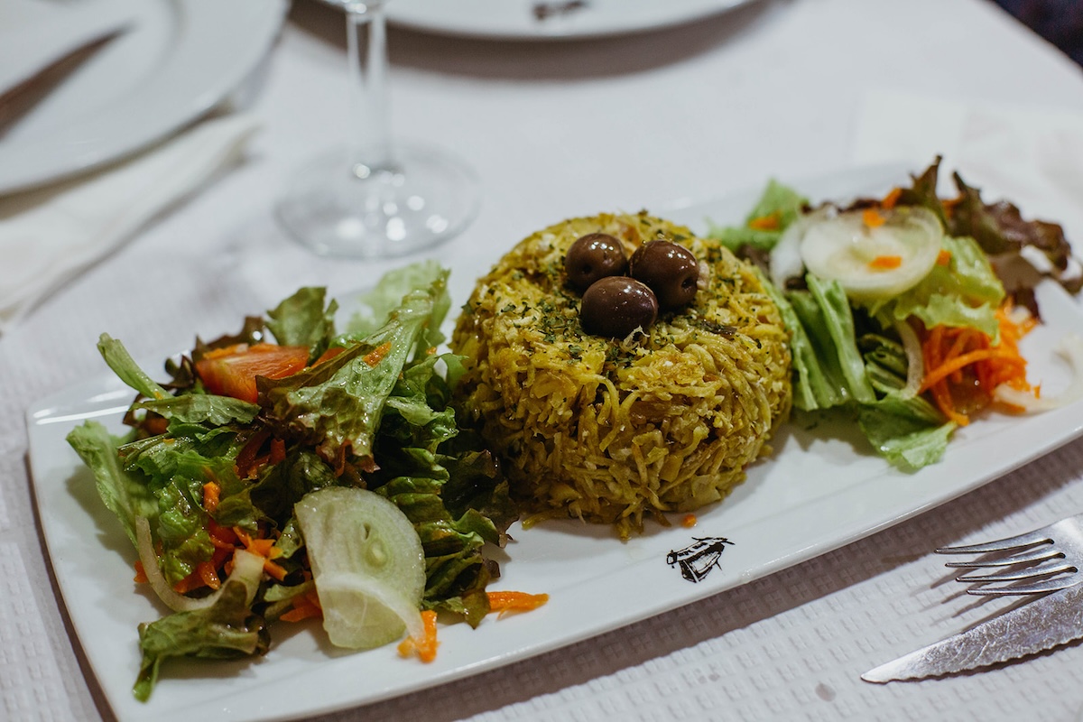 small plate of rice with olives and salad