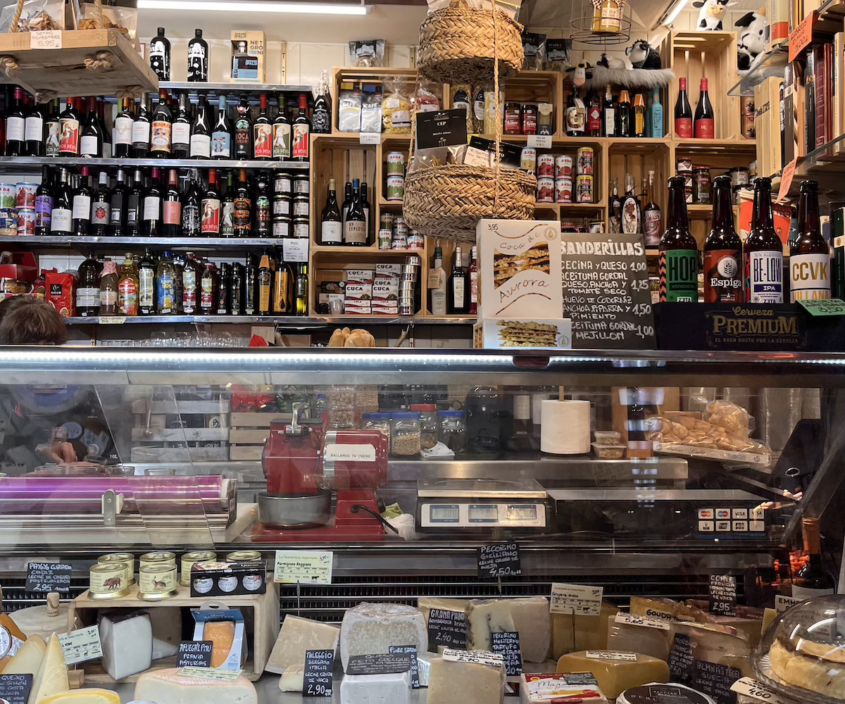 cheeses, wines, and beers being sold in a shop