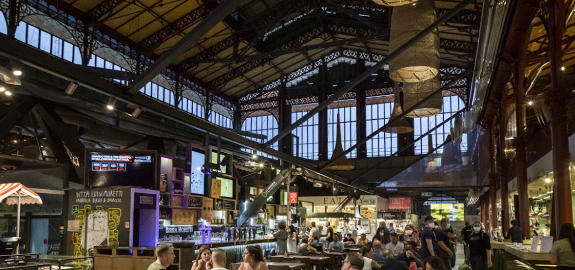 Interior of a large indoor food market with several restaurant stalls