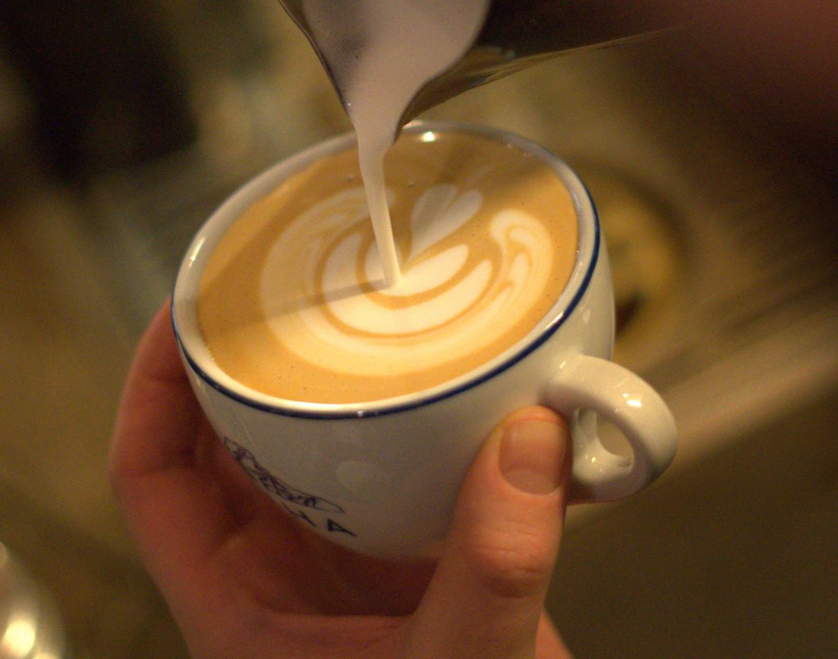 up-close shot of milk being poured into coffee cup