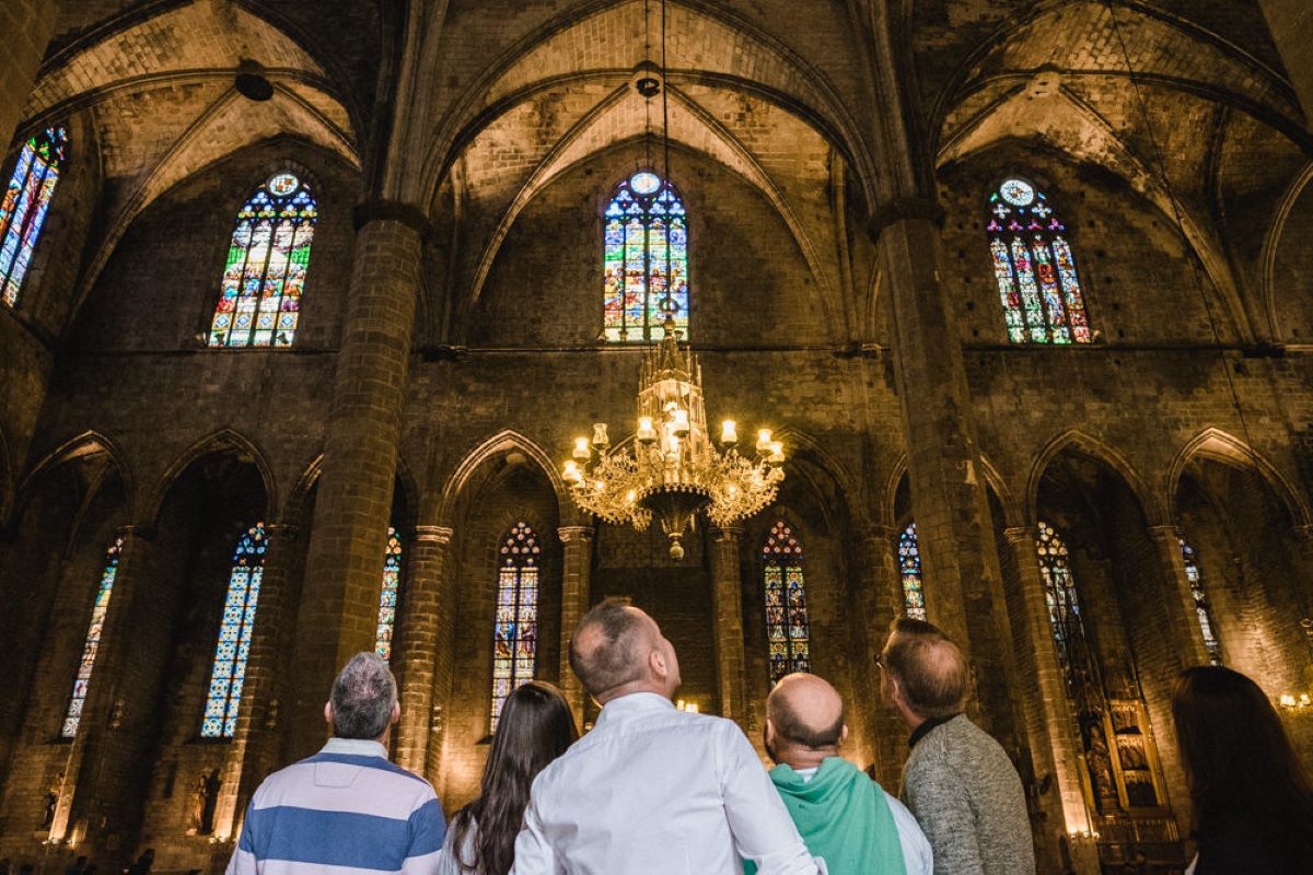 People looking up at Barcelona's Gothic cathedral's architecture. 
