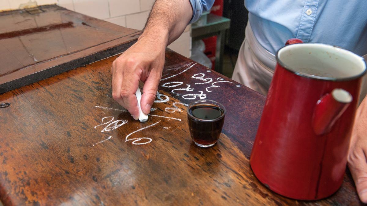 bar man keeping tab with chalk on bar