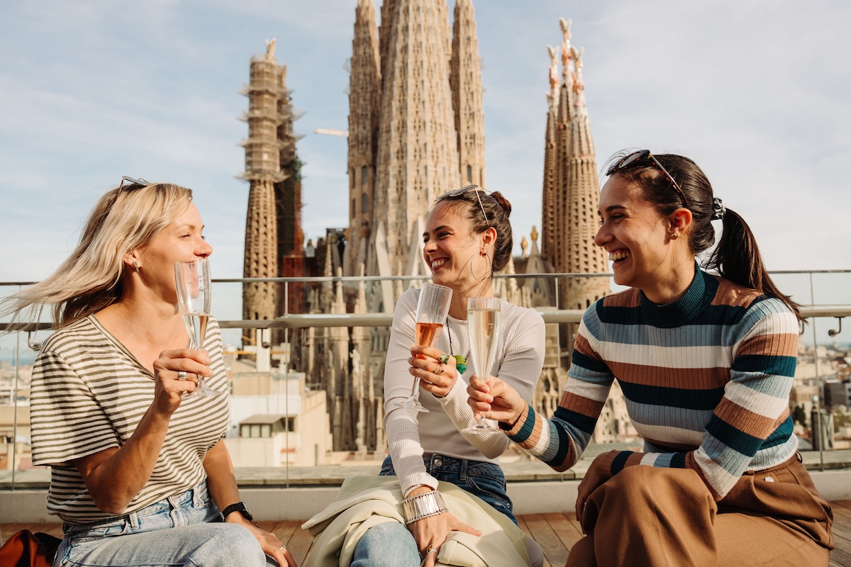 girls drinking cava with views of the sagrada familia church in the background in barcelona