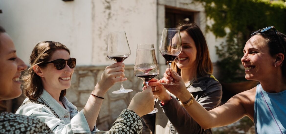 A group of women cheering and drinking Spanish red wines on a warm day.