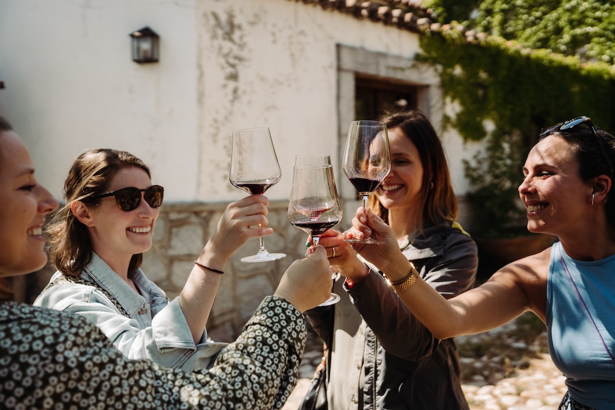 A group of women cheering and drinking Spanish red wines on a warm day.
