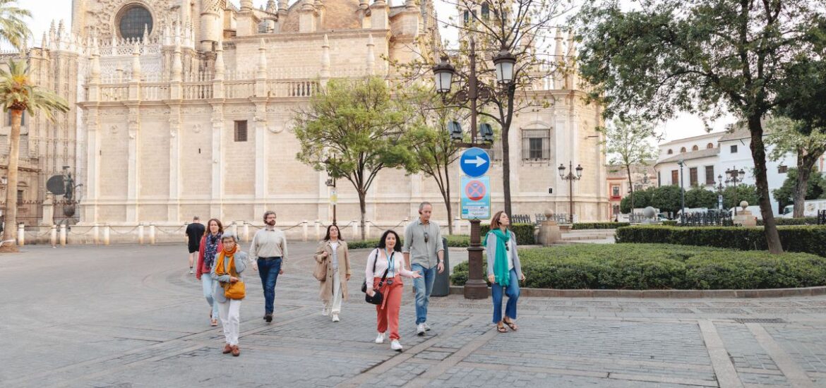 A group of people walking outside of Seville's cathedral