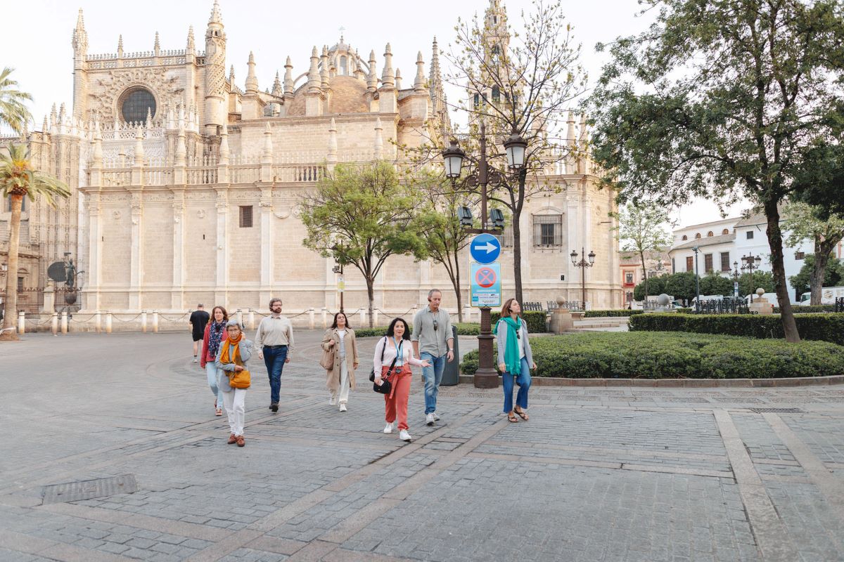 A group of people walking outside of Seville's cathedral