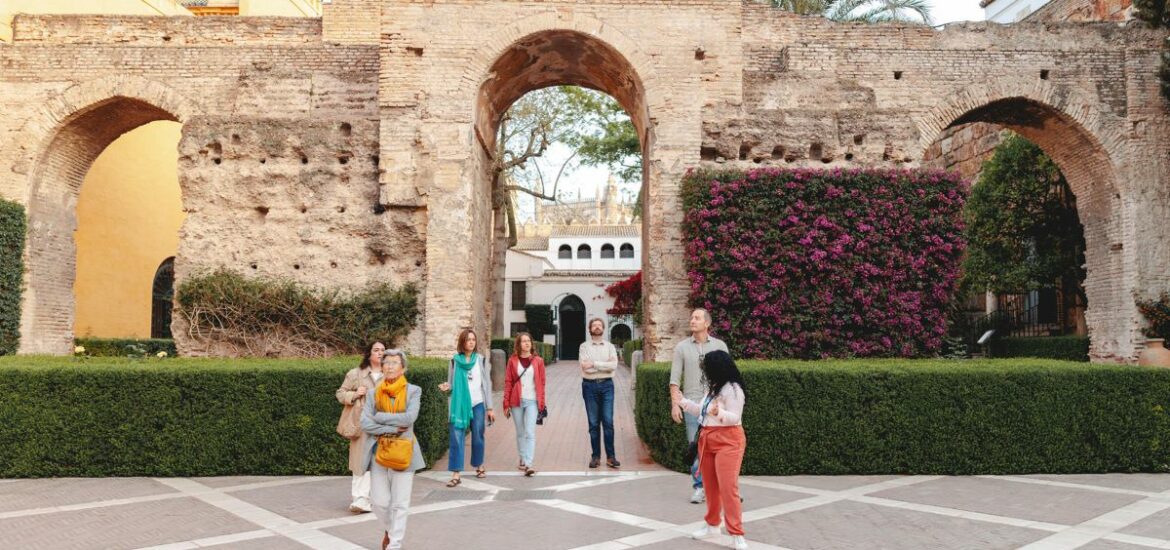 A guide leads a group on a tour at the Alcazar in Seville