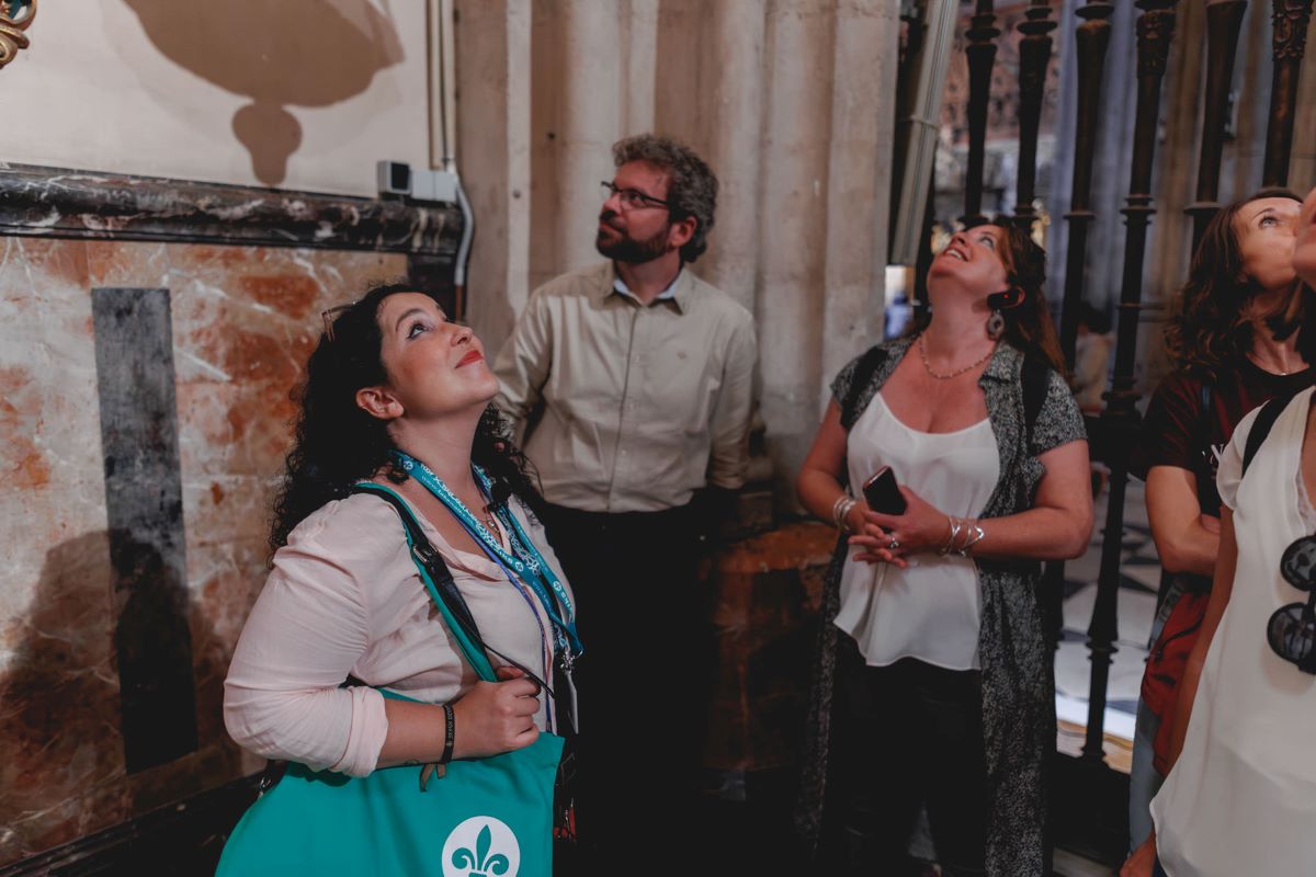 People looking up at the architecture at the Seville cathedral. 