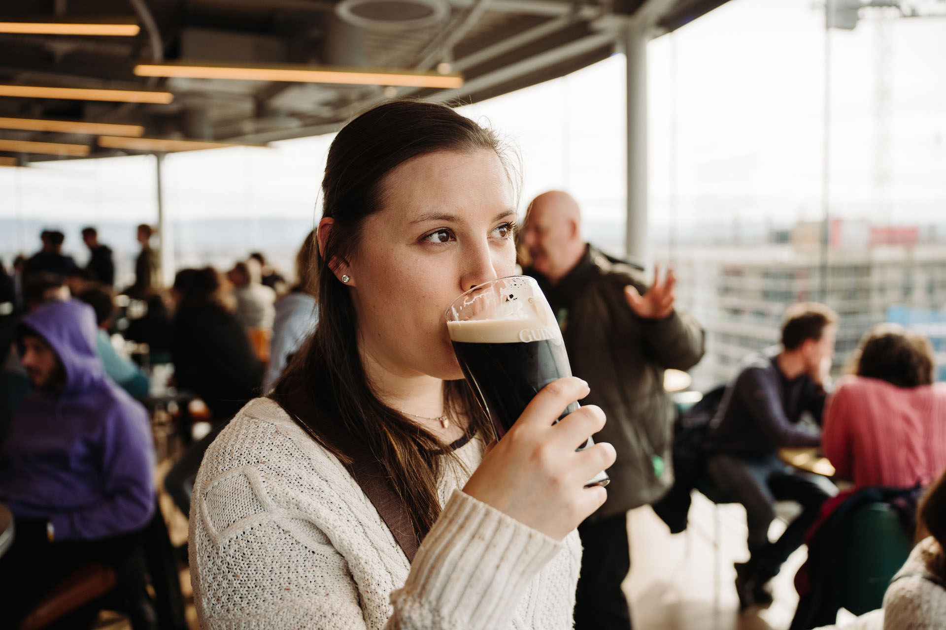 A person drinking a Guinness pint