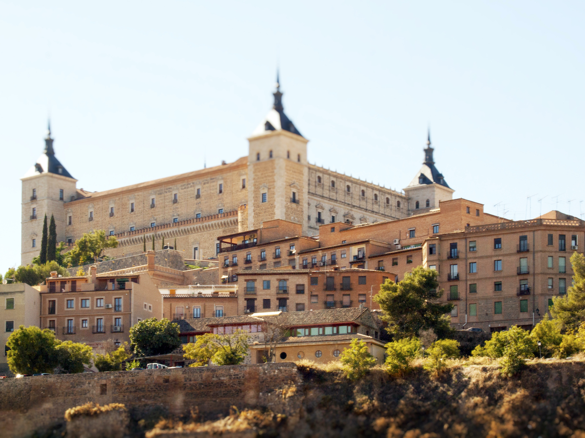 Large stone fortress on a hill overlooking a city.